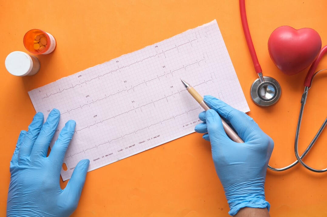 Person reviewing a health insurance checklist with a stethoscope on the desk
